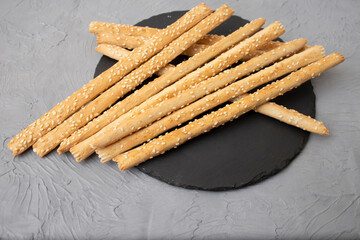 Bread sticks on a black stone slab