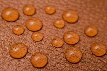 Round water drops on brown leather texture