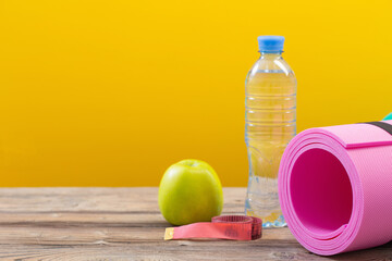 pink fitness mat on wooden floor, concept of health and sport