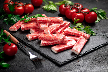 Crab meat on a stone board with fresh tomatoes and herbs. 