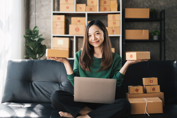 Start up small business, SME female owner checking order online to prepare to pack a box of goods for sale to customers, sme business idea.