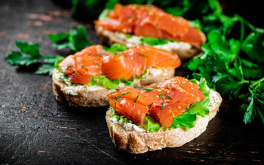 Sandwich with pieces of salmon and greens. 