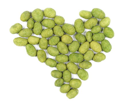 Wasabi coated peanuts in shape heart isolated on white background, top view