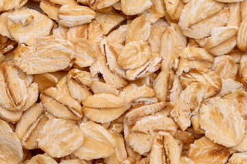 Macro photo of oatmeal.Texture, background of dry oatmeal.Healthy, delicious food, source of amino acids,minerals, vitamins.Top view