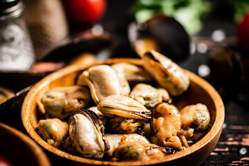 Pickled mussels in a wooden plate on the table. 