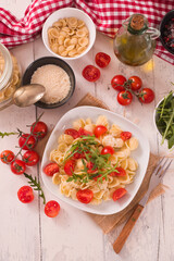 Orecchiette pasta with arugula and tomato.