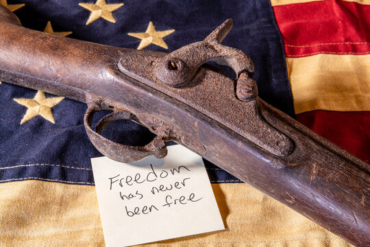 old musket gun on American flag with freedom has never been free note