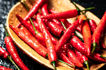 Chili peppers on a wooden plate. 
