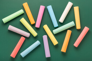 multicolor chalks like background over green, concept of education or business, top view