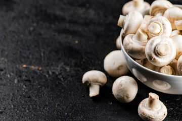 Fresh mushrooms champignons in a bowl on the table. 