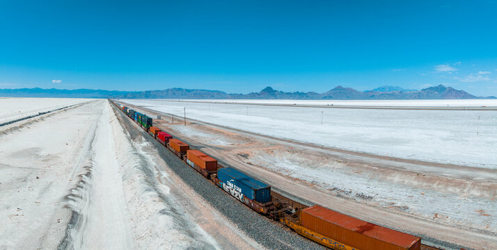 Cargo train passing by the desert Nevada, USA near Salt Flats. A railroad car is a vehicle used for the carrying of cargo on a railway.