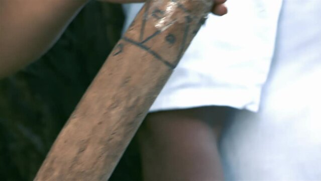 Woman Holding a Traditional Mapuche Rainstick, Pebbles or other Small Objects are placed inside the Rainstick to Create a Sound Reminiscent of Falling Rain or Falling Water. Close Up. 4K Resolution.