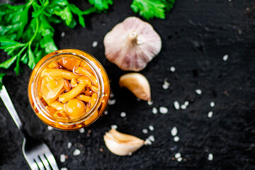 Marinated mushrooms with a glass jar with parsley and garlic. 