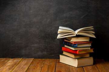 Back to school. Education background with books and apple over blackboard