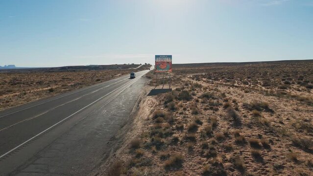 Welcome to Arizona state sign with white RV travel van driving down highway 89 near Page AZ, USA