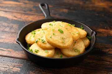 Healthy Cauliflower hash browns in cast iron frying pan on rustic wooden table