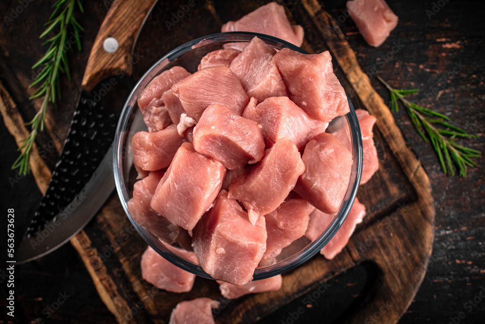 Sticker pieces of raw pork in a bowl on a cutting board.