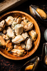 Pickled mussels in a wooden plate on the table. 