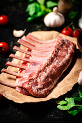 Raw rack of lamb with parsley and tomatoes. 