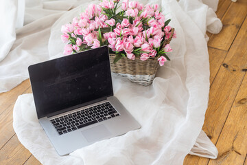 Table with laptop and flowers in a basket