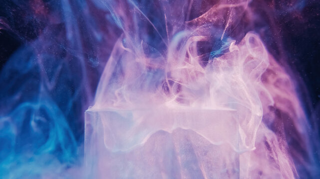 Glitter mist ice cube. Neon smoke. Dreamlike air. Defocused blue pink purple color light shimmering steam floating on dark abstract background.