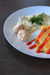 Plate of grilled chicken with mushroom sauce on wooden background.