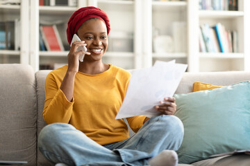 Obraz premium African american woman working from home, having phone conversation