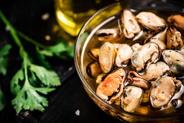 Pickled mussels in a bowl with parsley. 