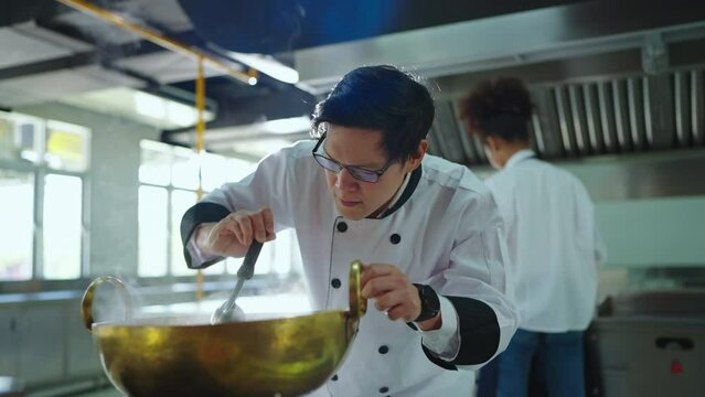 Professional chef looking to pasta at ketchen together. Team of professional cooks in uniform preparing meals for a restaurant in kitchen. Chef, Lifestyle, Education, Happiness, Cheerful concept.