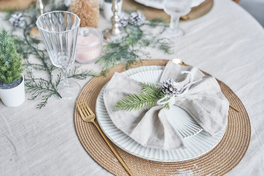 Close-up of Christmas serving, plate, spoon and fork, on a table with a light tablecloth, top view. Winter holiday theme, design with copy space. High quality photo