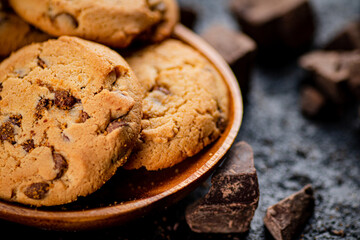 Wooden plate with cookies and pieces of milk chocolate. 