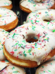 Fresh baked sweet white icing donuts with chocolate in the market. Pastry and sweet food theme....