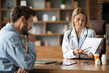 Obraz premium Doctor Woman Discussing Medical Test Results With Male Patient In Clinic