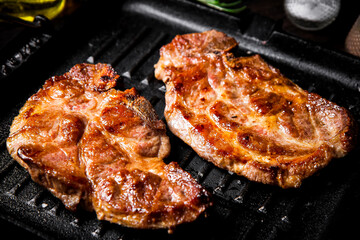 Flavorful grilled pork steak in a frying pan.