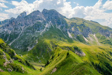 Fototapeta na wymiar Landscape typical of the Alps with beautiful green meadows, mountains and valleys on a nice sunny day . Popular travel destination. Summer tourism. Italian Alps, Dolomites, Italy.