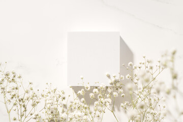 Summer minimal scene for beauty cosmetic product presentation made with white cube and wild flowers...