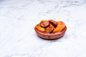 patatas riojanas con chorizo en una cazuela de barro naranja 