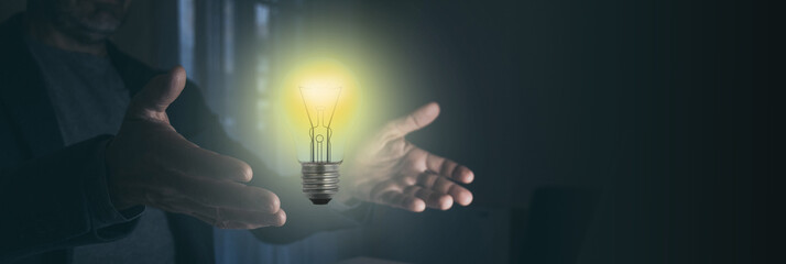 Obraz na płótnie Canvas Man hands holding light bulb illuminate. Creativity innovation, new idea, business growth concept.