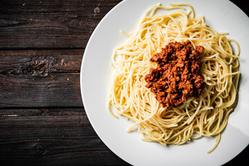 A full plate of spaghetti bolognese on the table. 