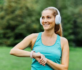 outdoor fitness jogging woman sport exercise portrait beautiful active body training health girl sportswear athlete workout headphone music listening time activitytracker smartwatch smart watch app