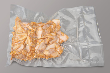Sliced chicken breast stew  in vacuum packed sealed for sous vide cooking isolated on Gray background in top view