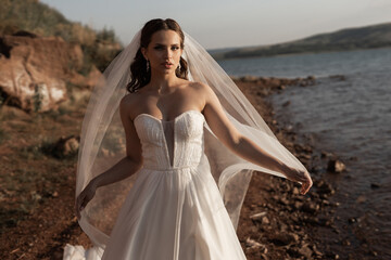 beautiful young bride in a wedding dress in summer in nature	

