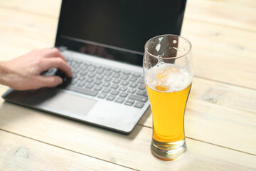 mug with beer on the background of hands and a laptop