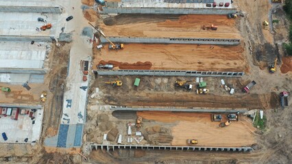 Construction of an open storage facility made of concrete for fodder at a livestock farm. Outdoor silo storage. Reconstruction. Construction equipment and workers are reconstructing the farm.