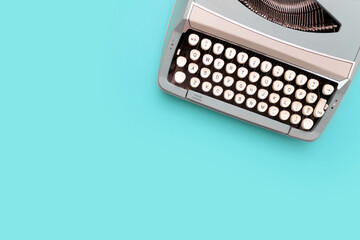 Overhead top view of a vintage aqua blue typewriter against a turquoise background - obrazy, fototapety, plakaty