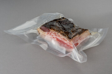 Guanciale Pork Jowl in vacuum packed sealed for sous vide cooking on Gray background