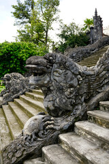 Fototapeta na wymiar Dragons stone figures as a stairs handrails outside Khai Dinh Mausoleum in Hue, Vietnam 