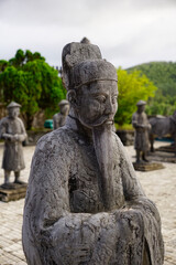 Stone figure of Mandarin or bureaucrat standing outside Khai Dinh Mausoleum in Hue, Vietnam                           