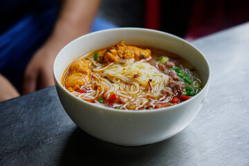 Delicious bowl of Bun Bo Hue served as breakfast at a street food stall in Hue, Vietnam