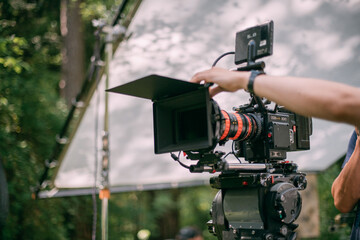 Professional cinema and video camera on the set. Shooting shift, lighting fixtures, shooting equipment and the team.